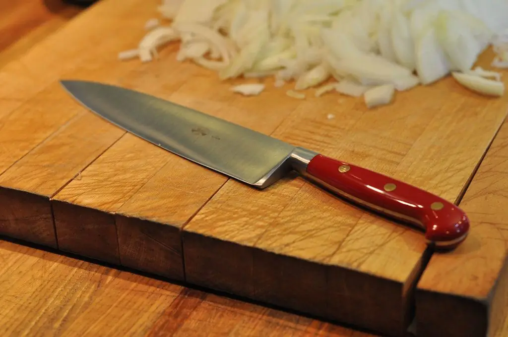Carbon-steel chef knife resting on a linen cloth