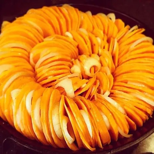 Vegetables cooking in a seasoned cast-iron skillet